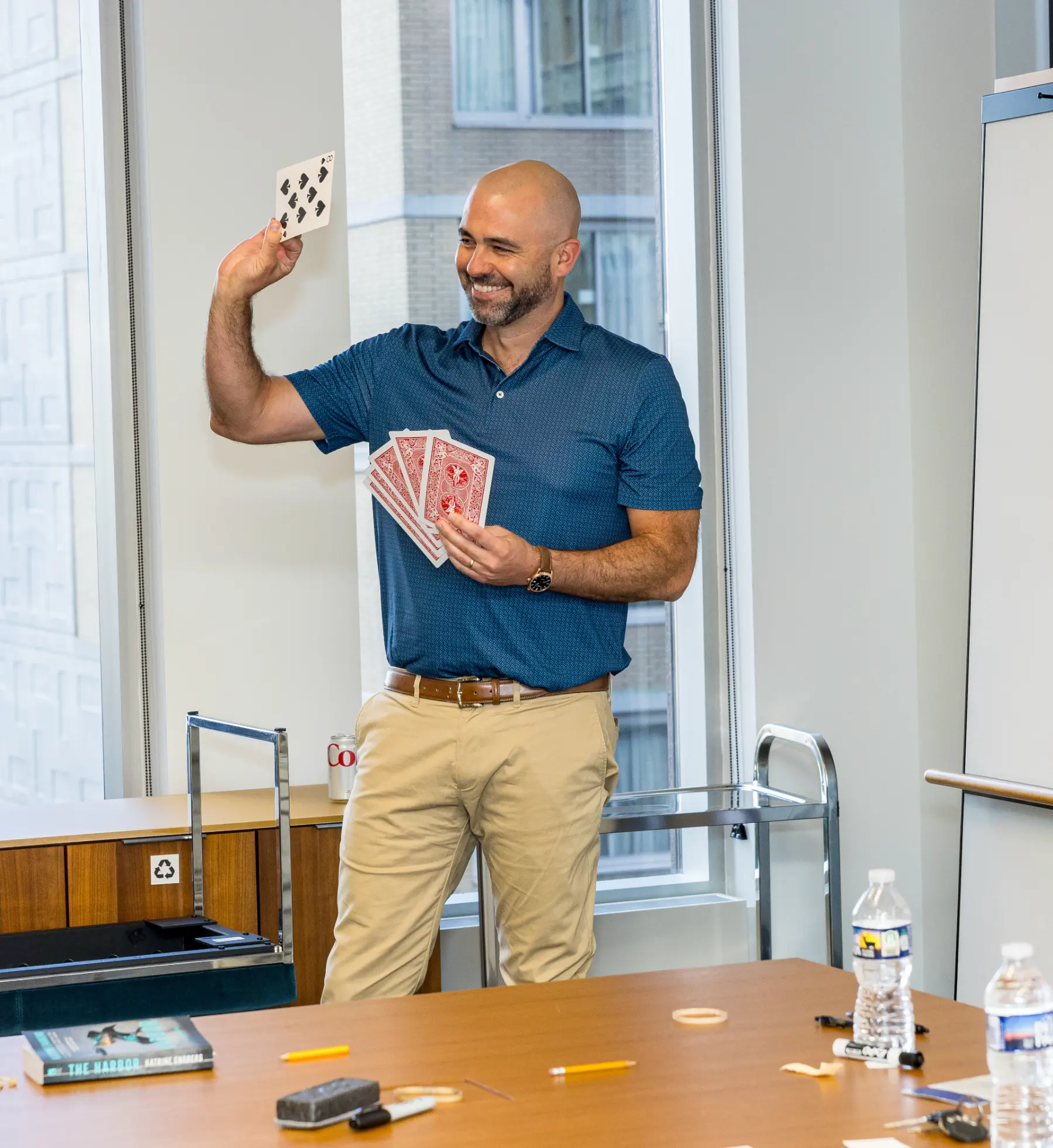 An audience member holds up a playing card during an interactive card routine