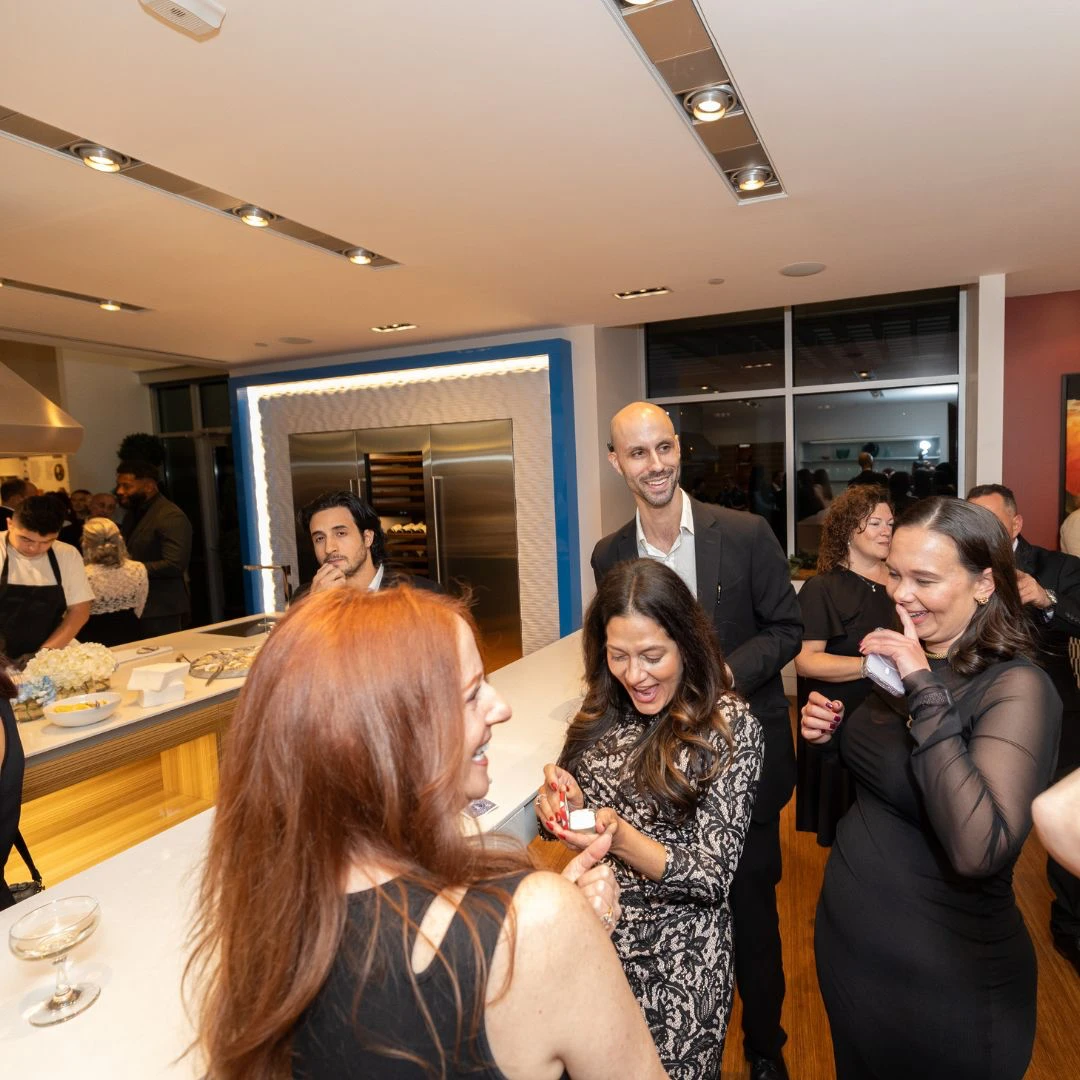 Magician Jesse Dameron performing strolling magic for guests in black-and-white attire at the Sub-Zero, Wolf, and Cove showroom, Philadelphia Navy Yard