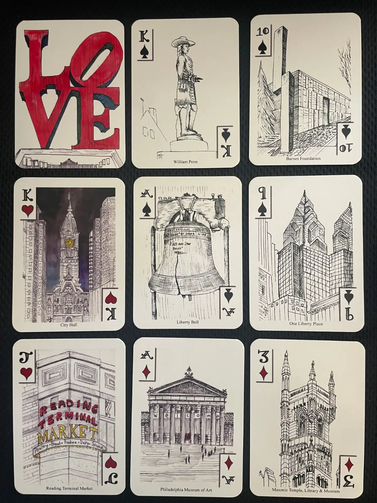 Jesse Dameron's deck of landmark playing cards, showing hand-drawn cards of the LOVE statue, William Penn, the Barnes Foundation, City Hall, the Liberty Bell, One Liberty Place, Reading Terminal Market, the Philadelphia Museum of Art, and the Masonic Temple.