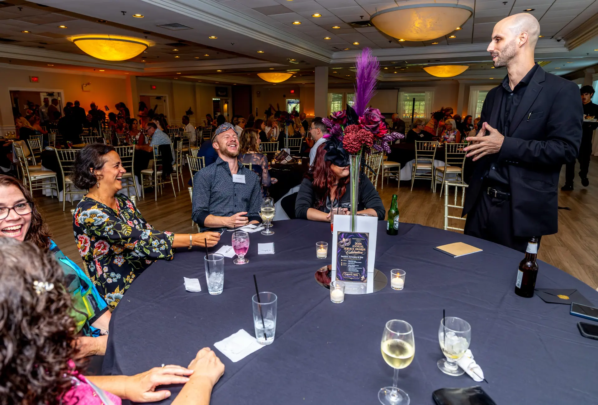 Magician and mentalist Jesse Dameron entertaining a table of laughing guests in the Grand Ballroom at Downingtown Country Club