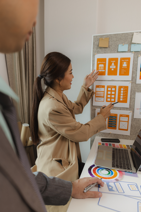 Hands of business people pointing and discussing charts and graphs on printed reports at a desk.