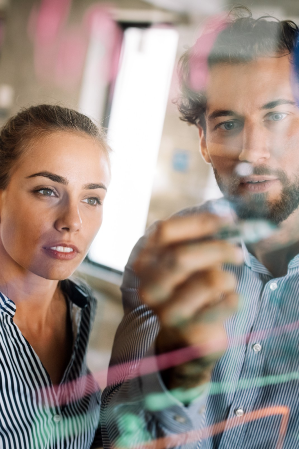 Hands of business people pointing and discussing charts and graphs on printed reports at a desk.