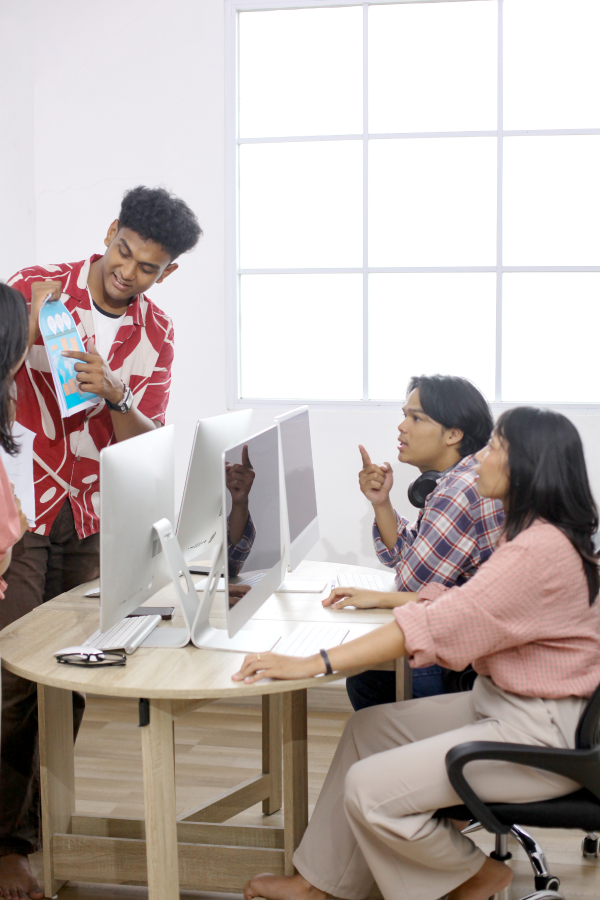 Hands of business people pointing and discussing charts and graphs on printed reports at a desk.