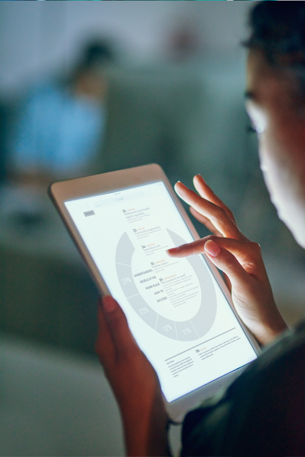 Hands of business people pointing and discussing charts and graphs on printed reports at a desk.