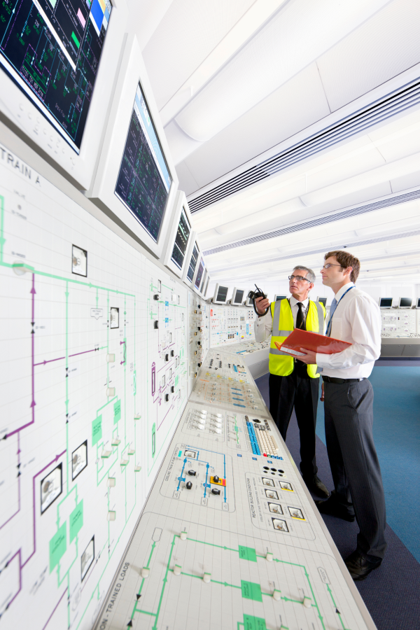 Hands of business people pointing and discussing charts and graphs on printed reports at a desk.