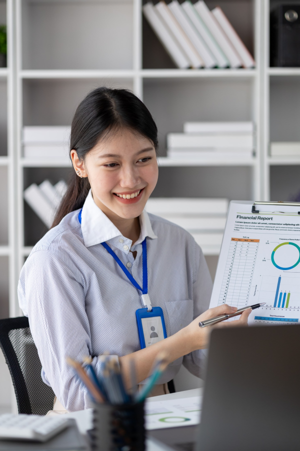 Hands of business people pointing and discussing charts and graphs on printed reports at a desk.