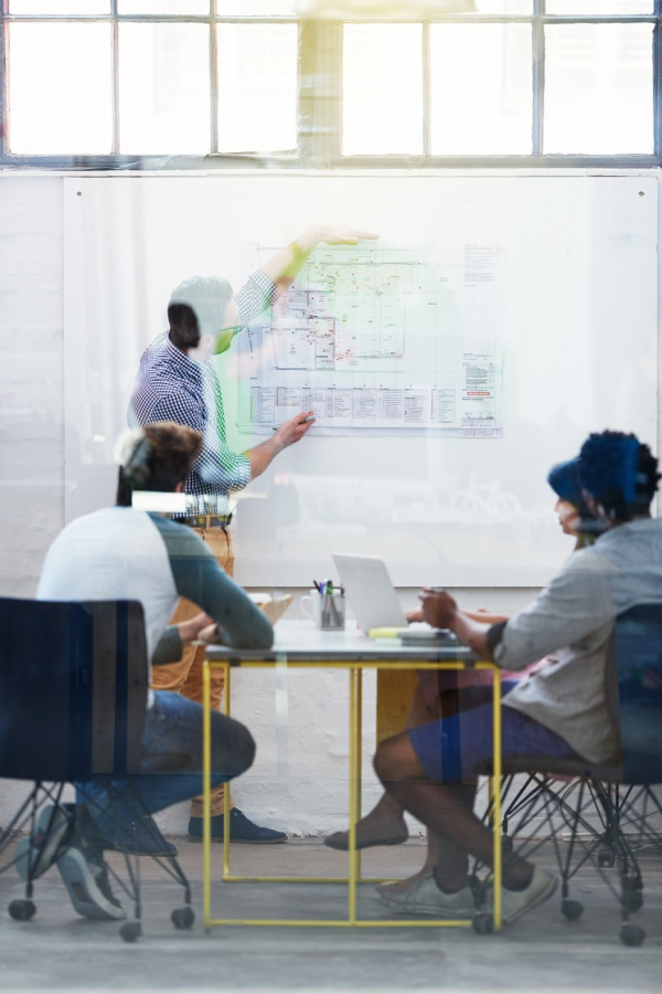 Hands of business people pointing and discussing charts and graphs on printed reports at a desk.