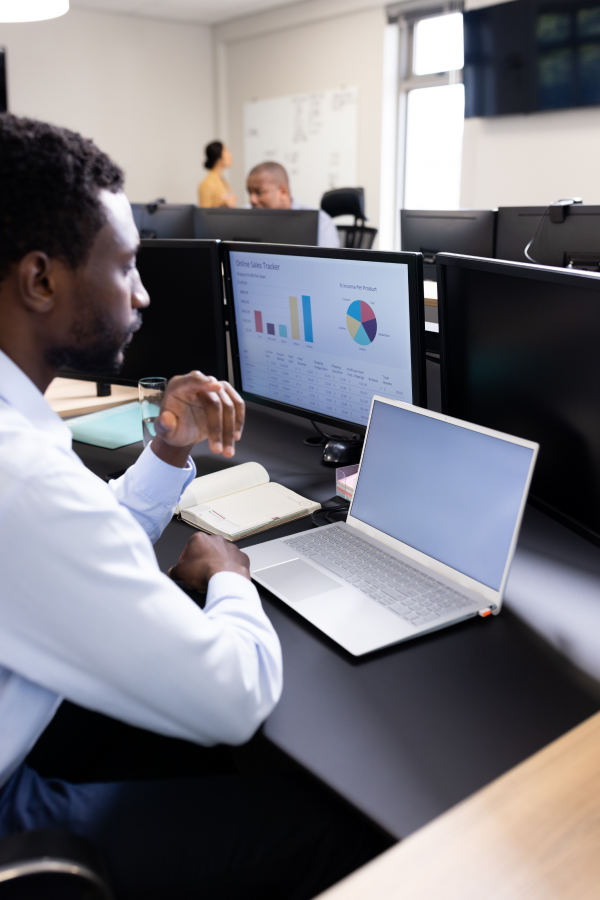Hands of business people pointing and discussing charts and graphs on printed reports at a desk.