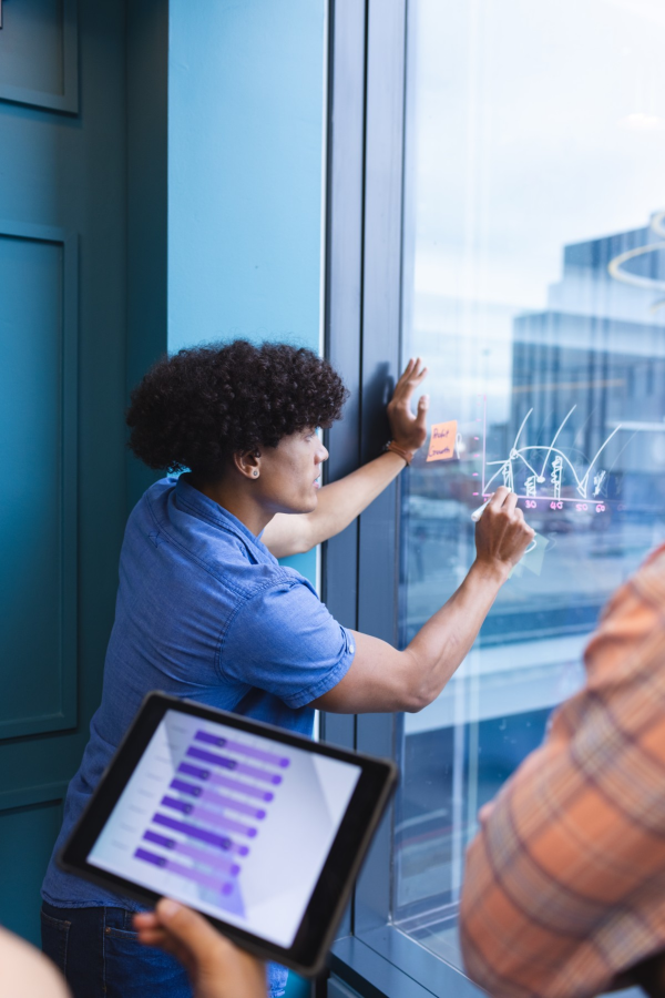 Hands of business people pointing and discussing charts and graphs on printed reports at a desk.