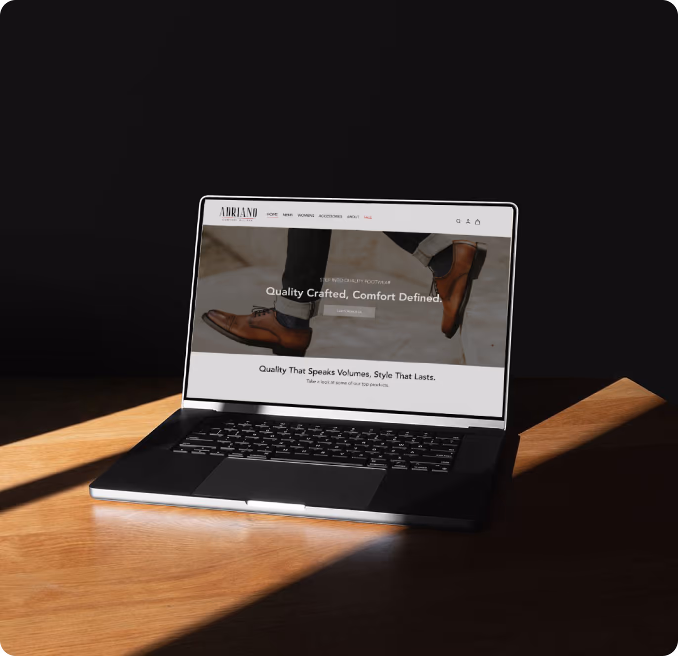 Open laptop on wooden table displaying website with brown dress shoes and text about quality crafted footwear.