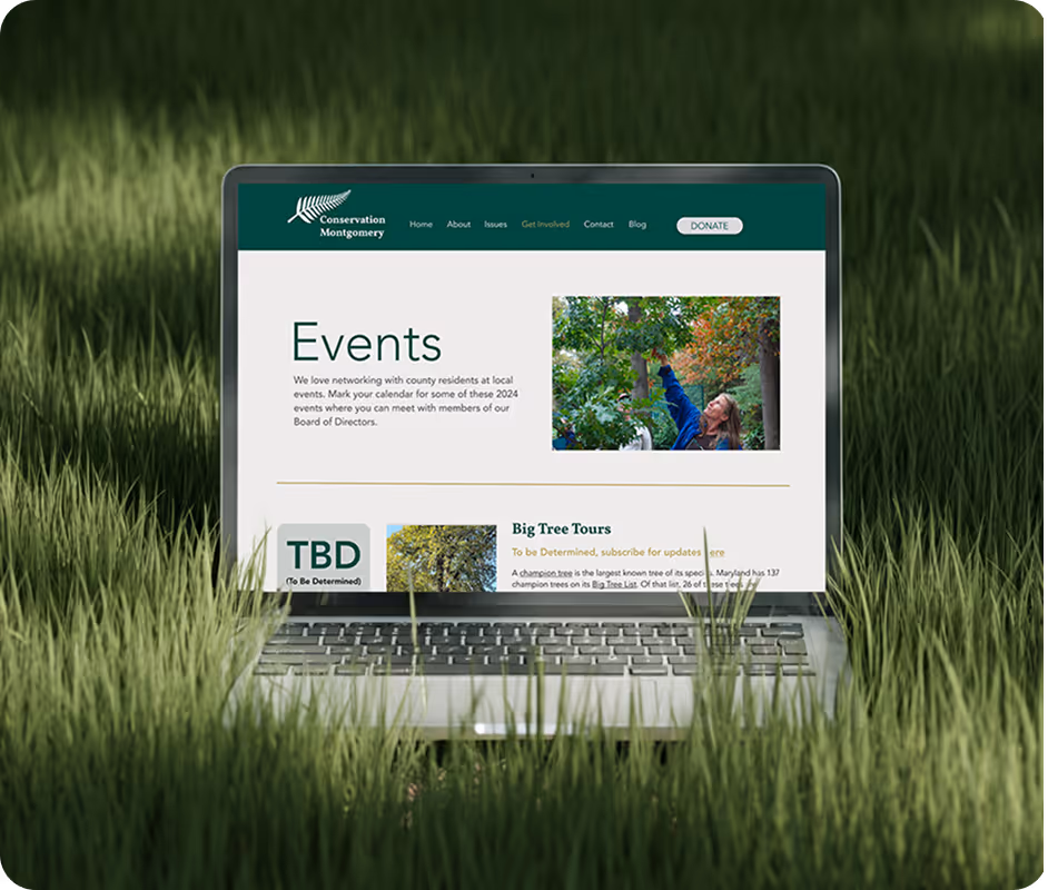 Laptop in tall grass displaying Conservation Montgomery website events page with information about local events and big tree tours.