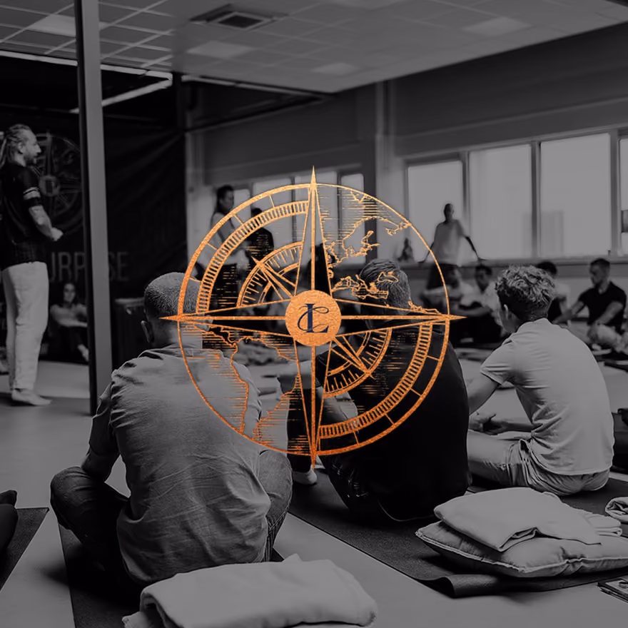 Groep mensen zittend op yogamatten in een studio tijdens een les, met kompaslogo overlay.
