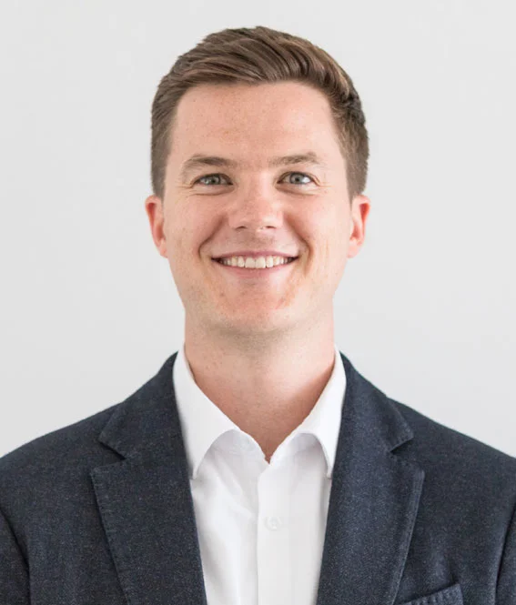 Smiling portrait of Callum Quigley, Associate Partner for Delivery and Sales, London.