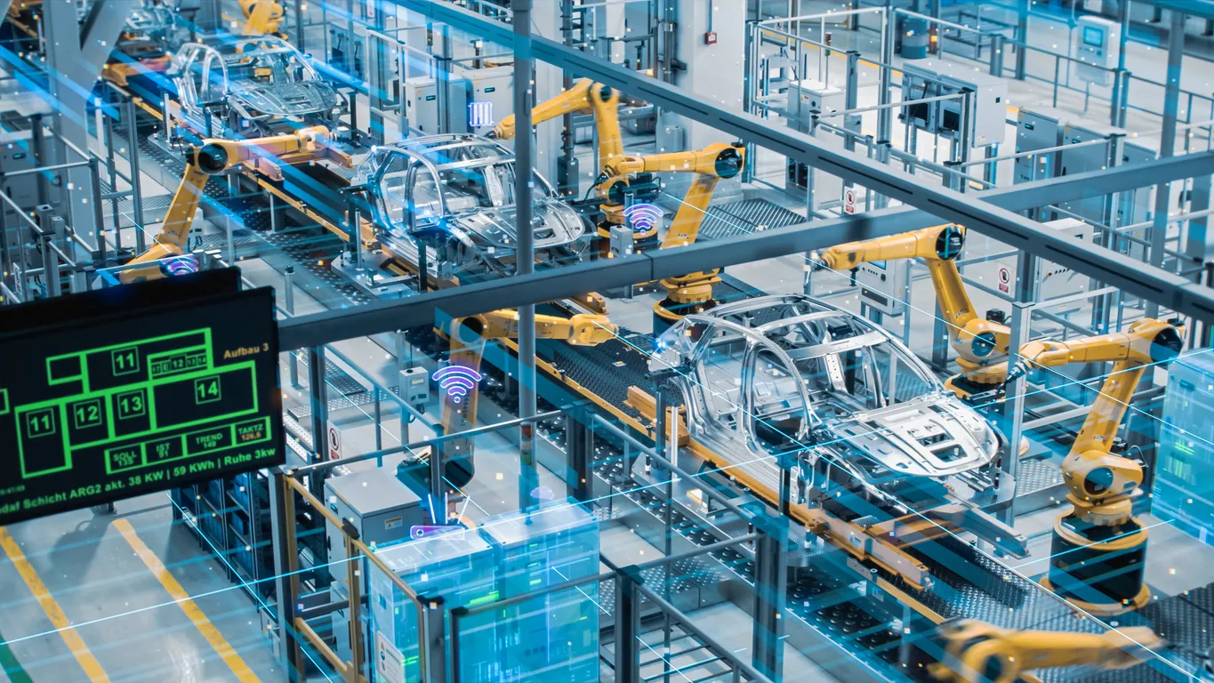 High-tech automotive assembly line with robotic arms assembling car frames in a smart factory equipped with digital monitoring and automation systems.