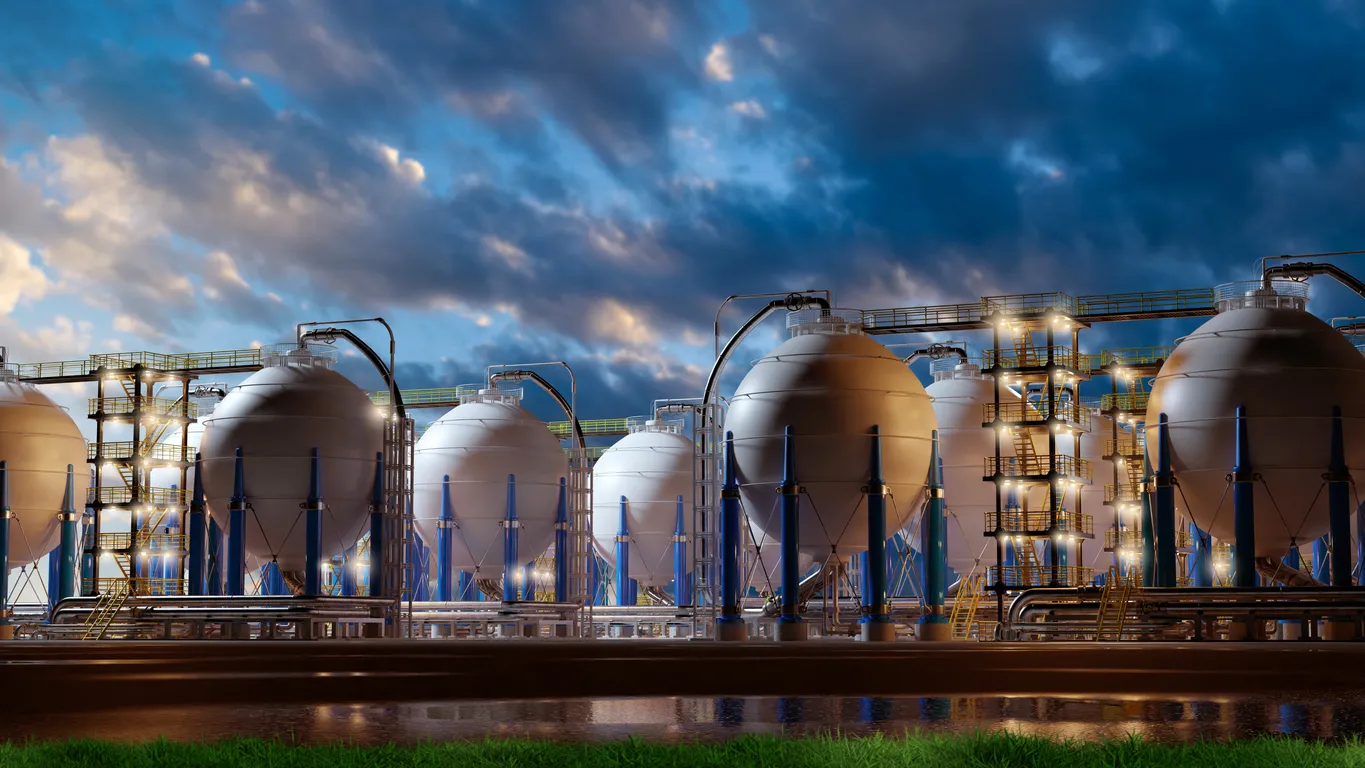Industrial gas storage facility with large spherical tanks, illuminated under a dramatic evening sky, representing energy infrastructure and petrochemical processing.