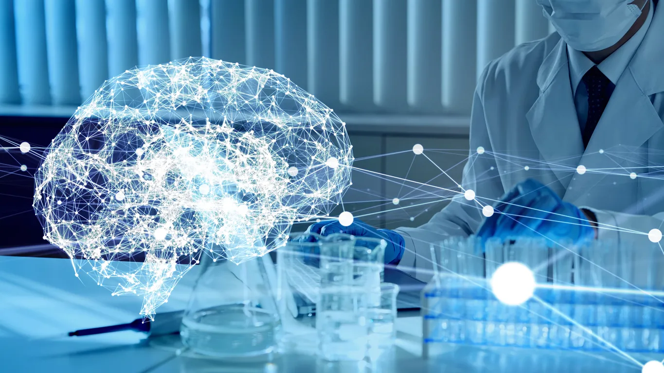 A scientist in a lab coat and gloves works with test tubes. A glowing digital brain illustration overlaps, symbolizing neuroscience research.