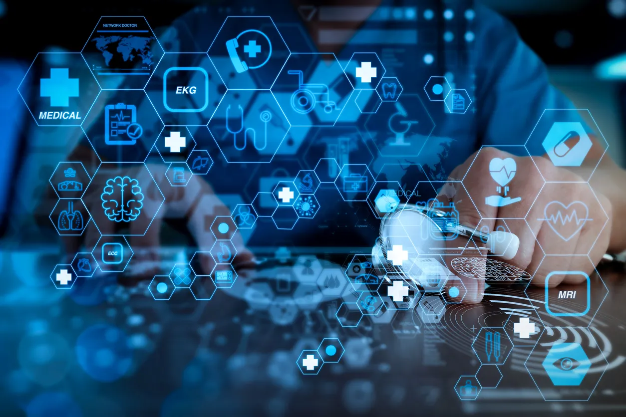 A person uses a digital tablet, surrounded by floating medical icons like EKG and MRI in blue hexagons. The scene conveys advanced healthcare technology.