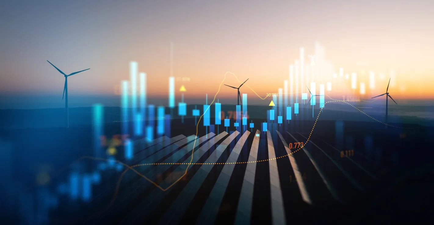 Silhouettes of wind turbines against a sunset backdrop, overlaid with blue and orange financial graphs, symbolizing renewable energy trends.