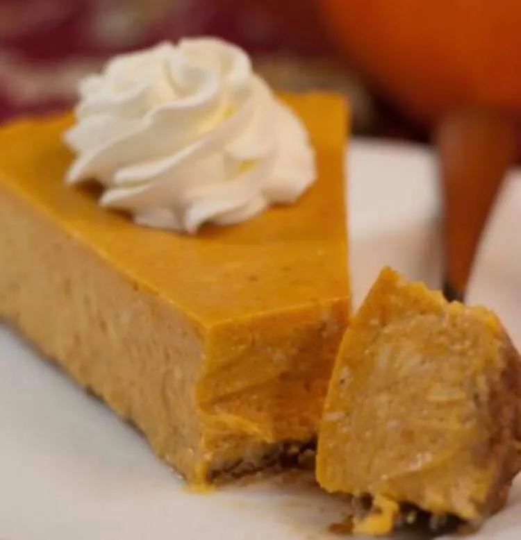 A slice of delicious pumpkin pie with whip cream on top