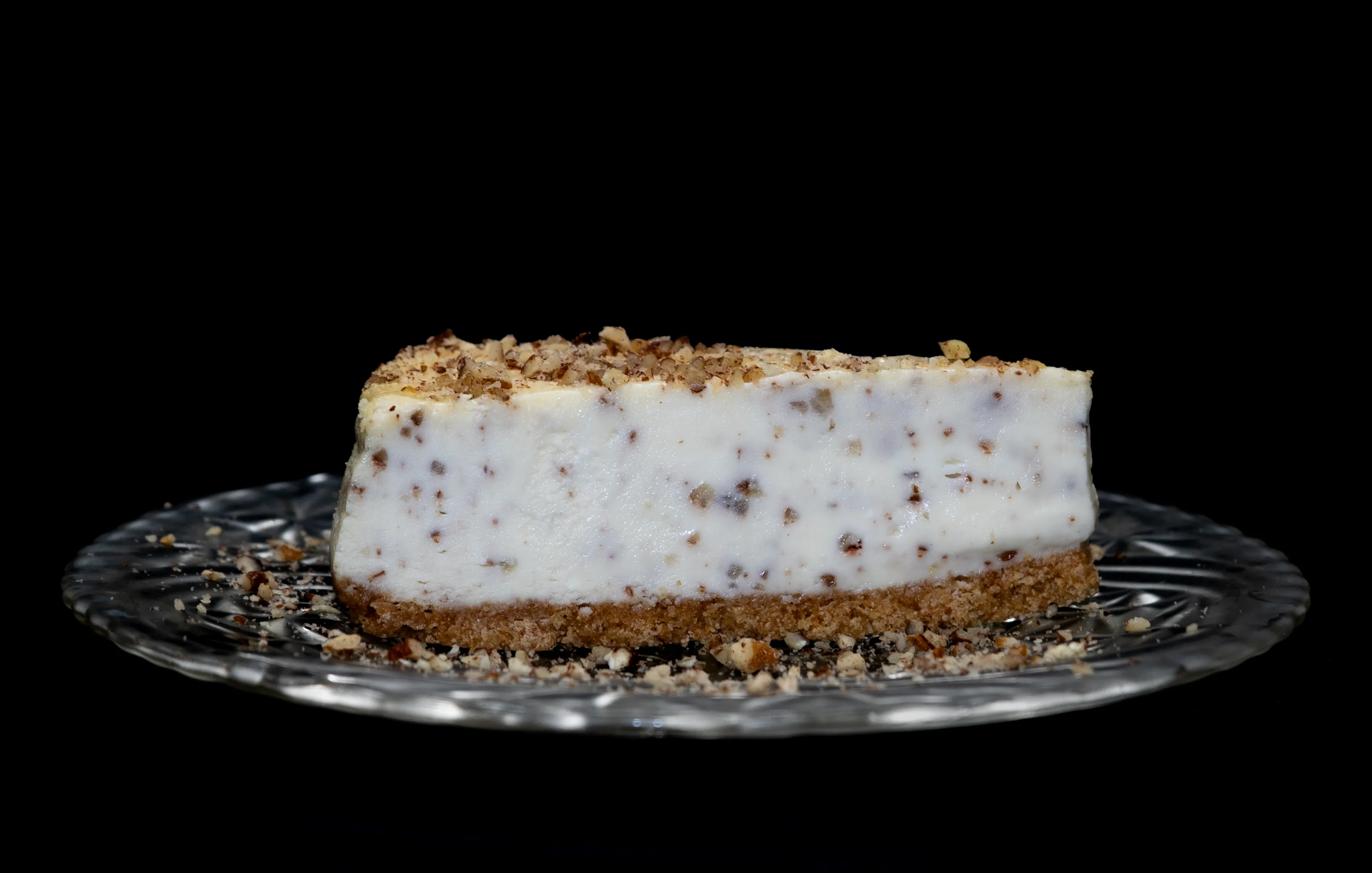 A slice of butter pecan pie sitting on top of a glass plate