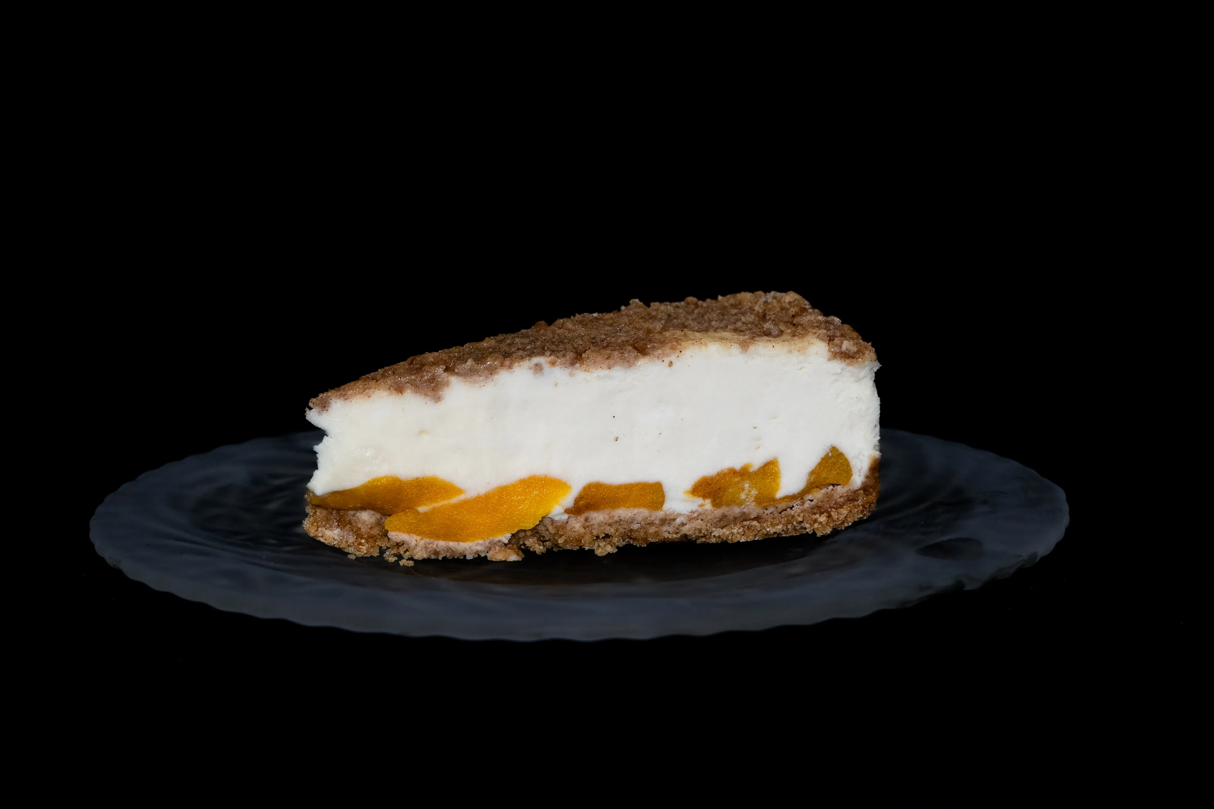 A slice of peach cobbler pie sitting on top of a glass plate