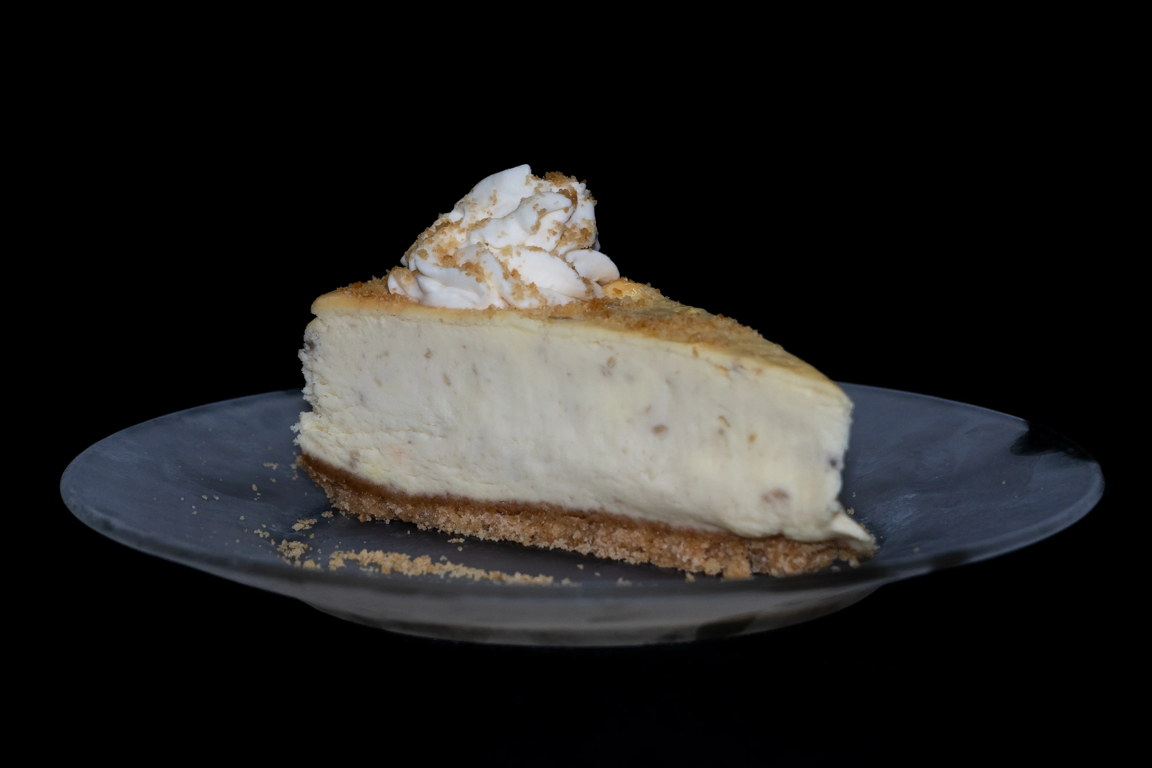 A slice of Banana Pudding with whip cream pie sitting on top of a glass plate