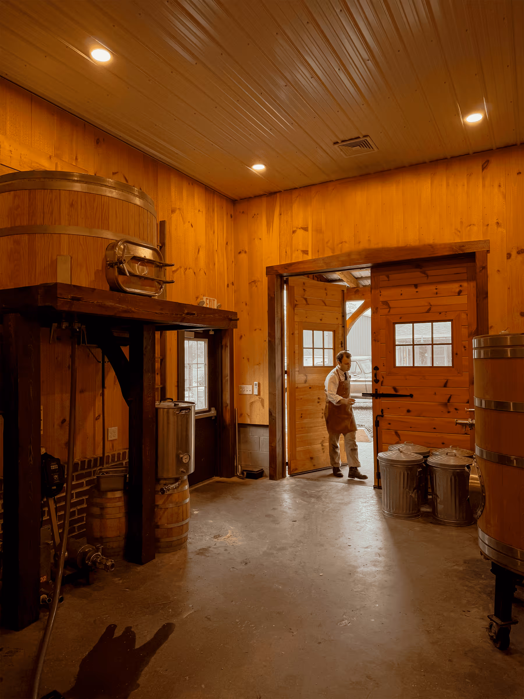 Wooden interior of a brewery with brewing equipment and metal containers