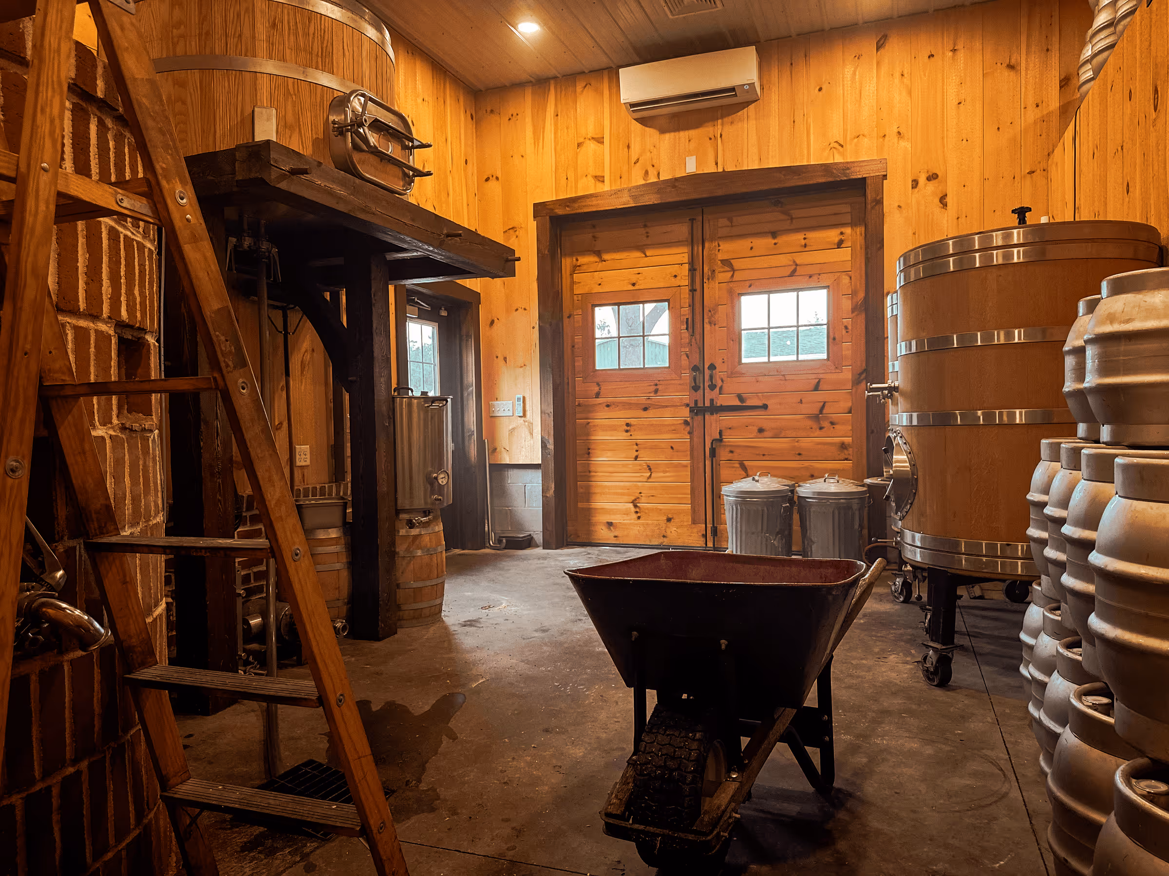 Wooden interior of a craft brewery with fermentation tanks and equipment