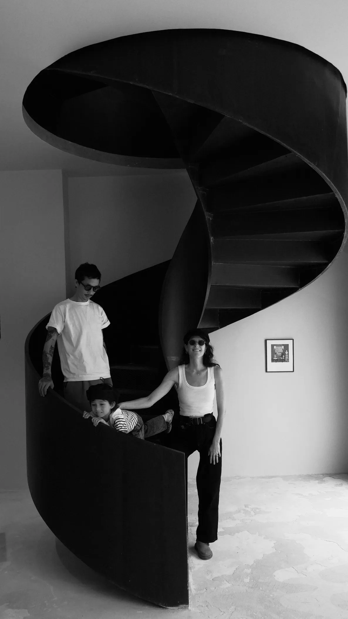 The Rigotang family on the gallery's spiral staircase, black and white