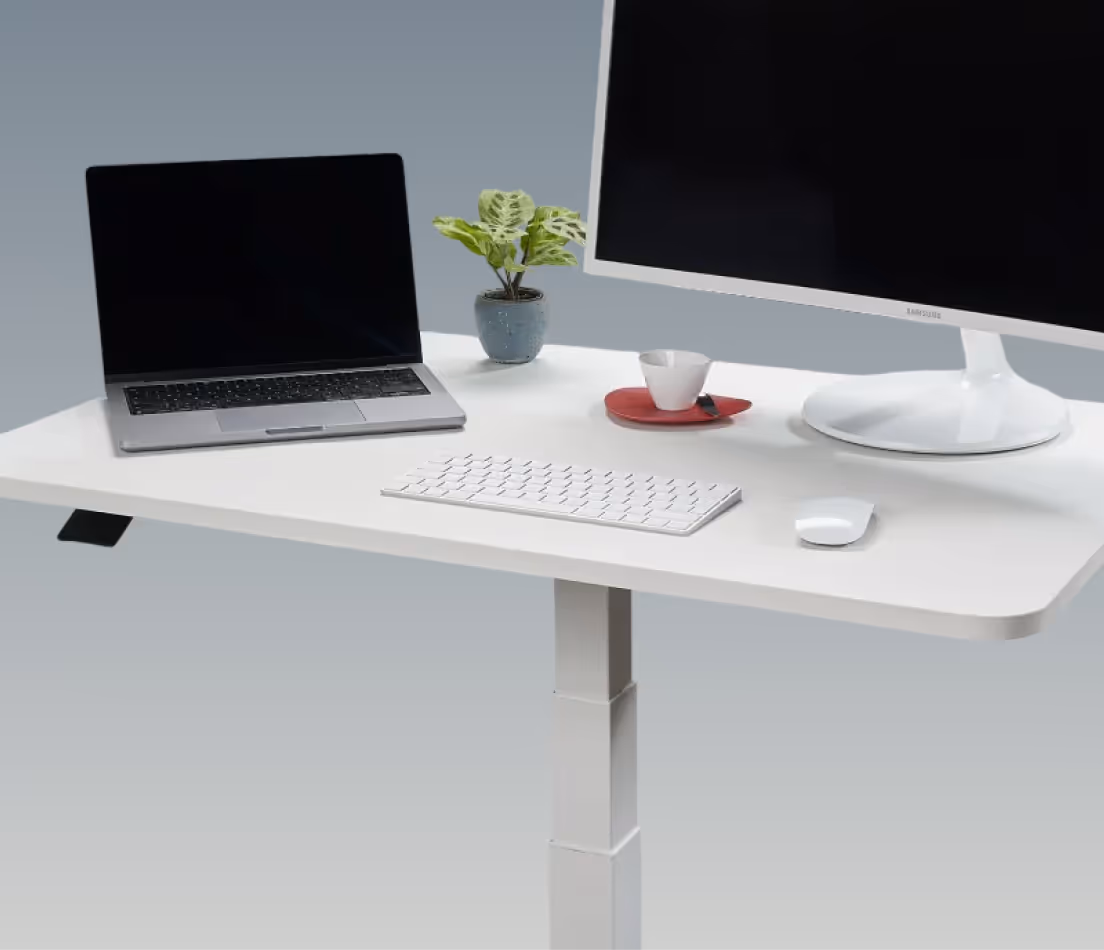 Arbeitsfläche des weißen myhomii Stehschreibtischs mit Laptop, Monitor und Zubehör