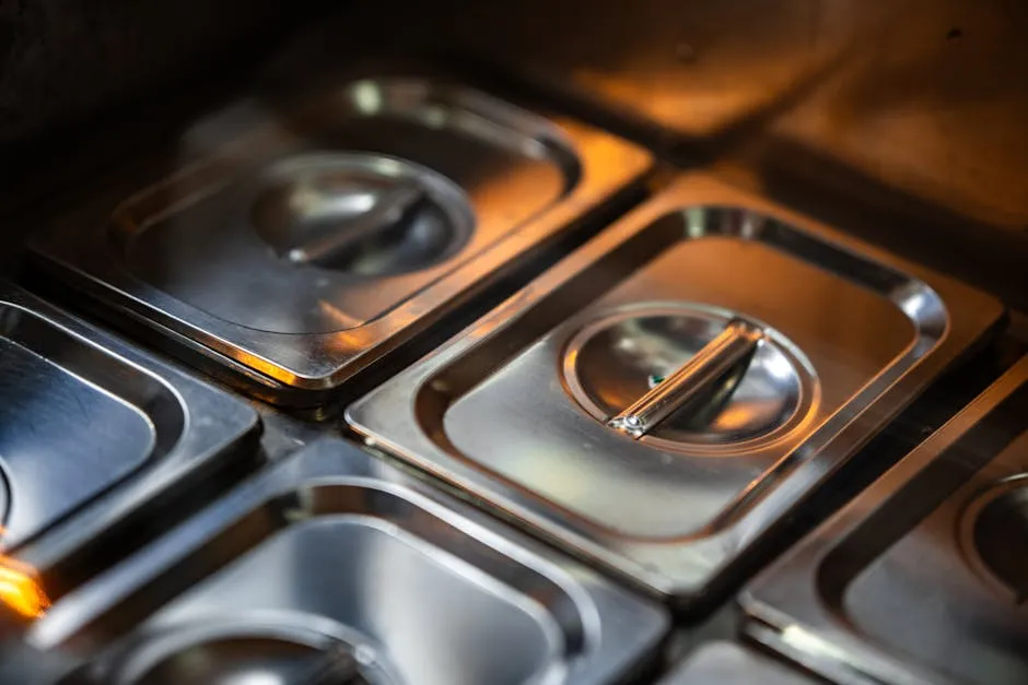 Stacks of stainless steel reusable food containers in a professional kitchen setting