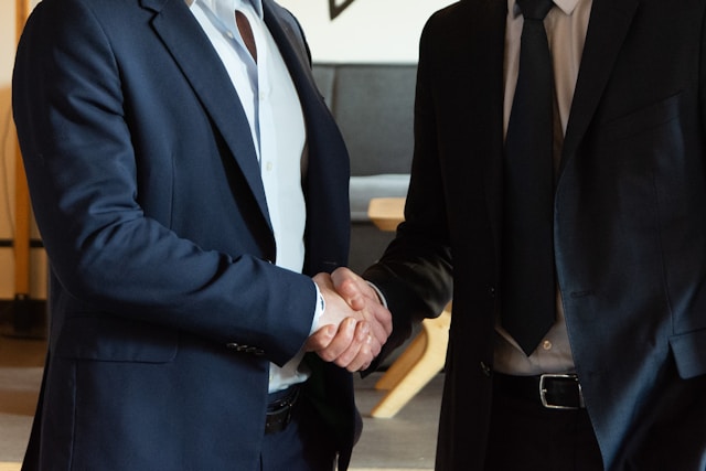 two men shaking hands in suits