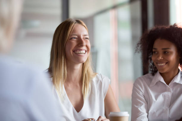 Two colleagues discussing work together at a desk during a focused conversation.