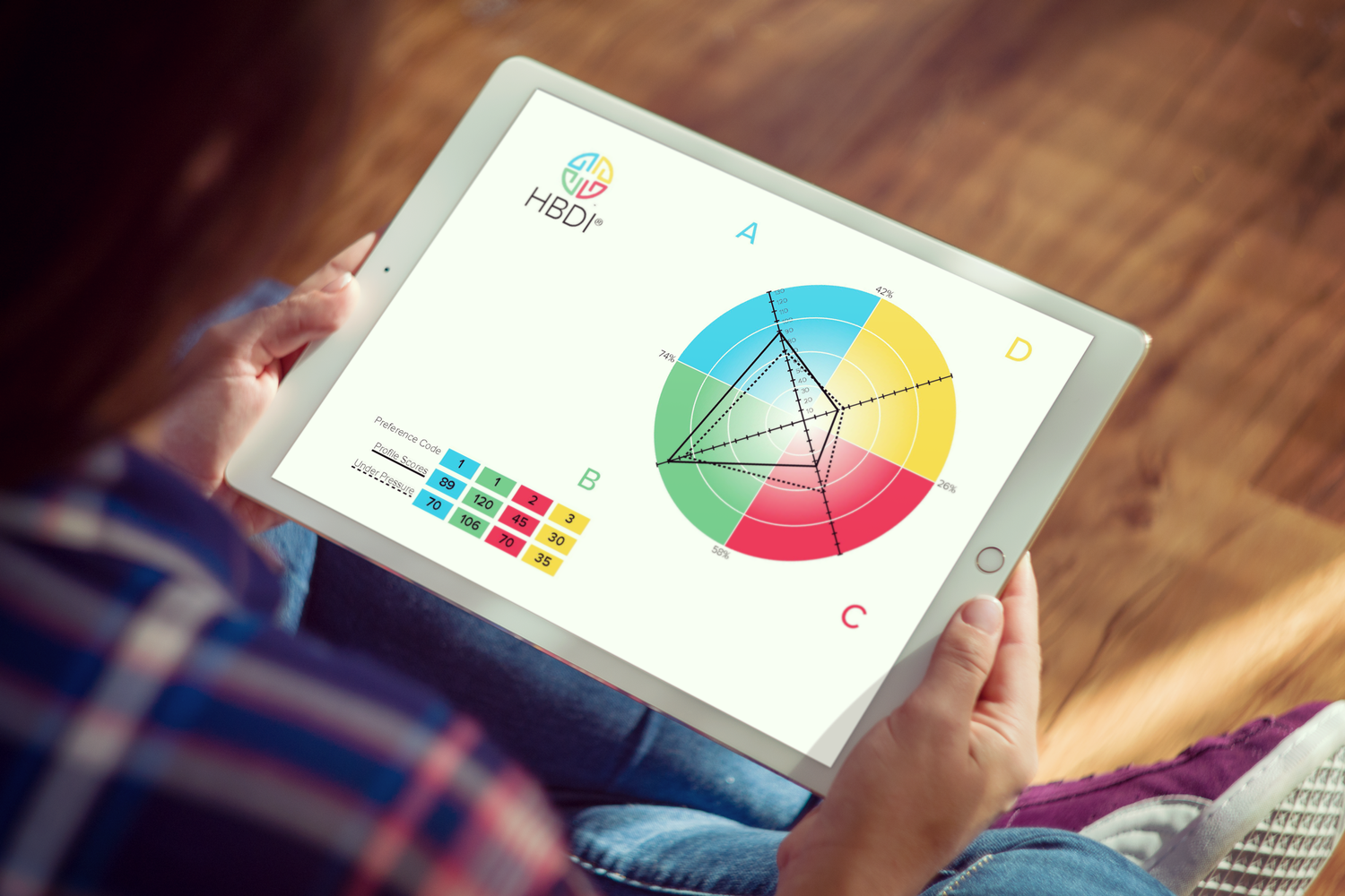 Three coworkers smiling and discussing ideas while gathered around a laptop in a bright office setting.