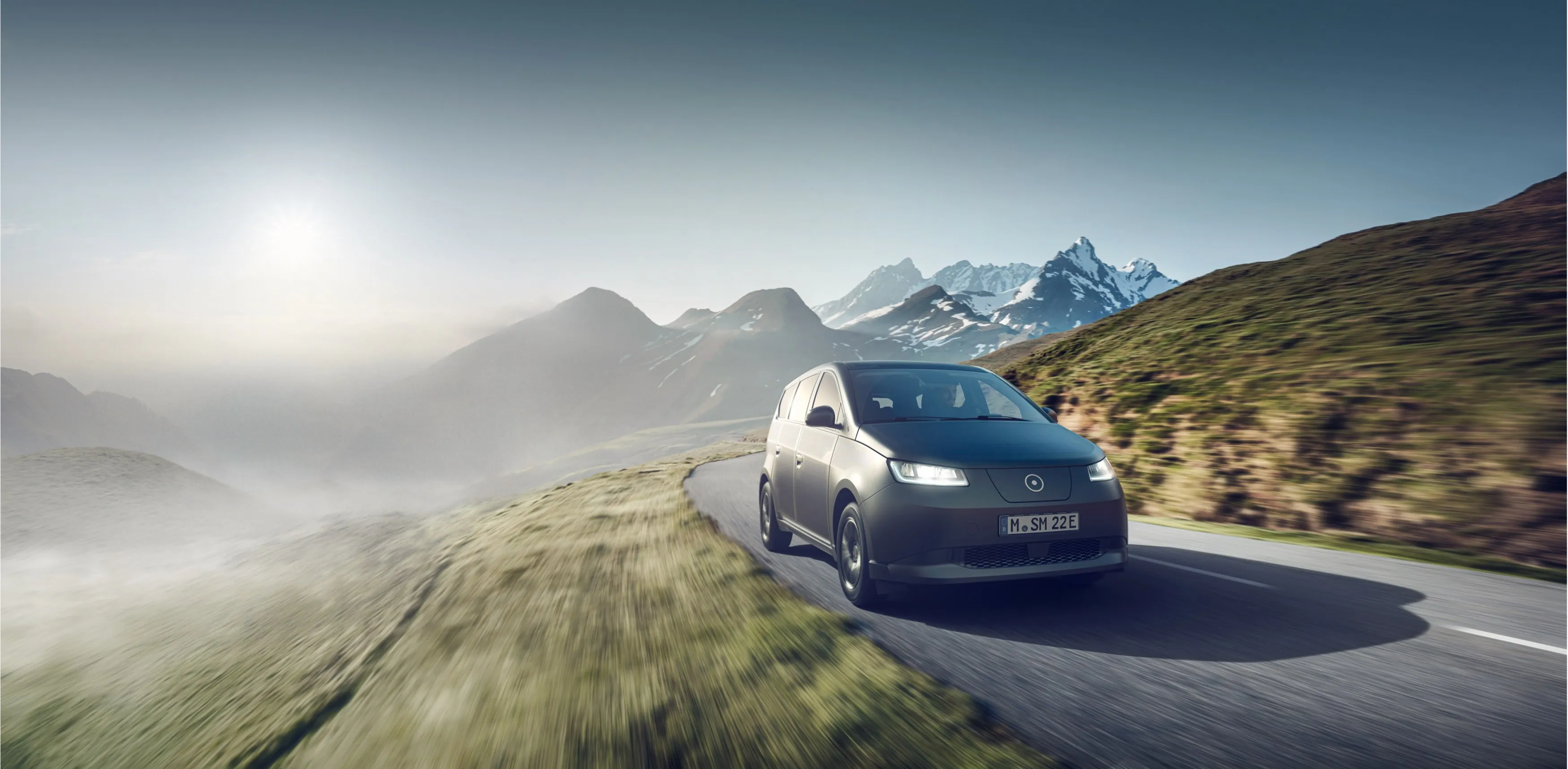 a car driving on a road with mountains in the background