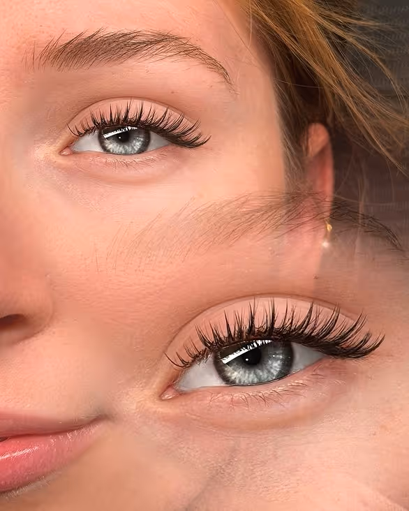 Nahaufnahme eines weiblichen Gesichts mit blauem Auge und langen Wimpern, mit einer unscharfen doppelten Belichtung desselben Auges und Gesichts.