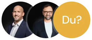 Porträt zweier Männer mit dunklem Hintergrund, neben einem gelben Kreis mit der Aufschrift ‚Du?‘