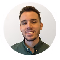 Porträt eines lächelnden jungen Mannes mit kurzem braunen Haar und Dreitagebart, der ein grünes Hemd trägt.