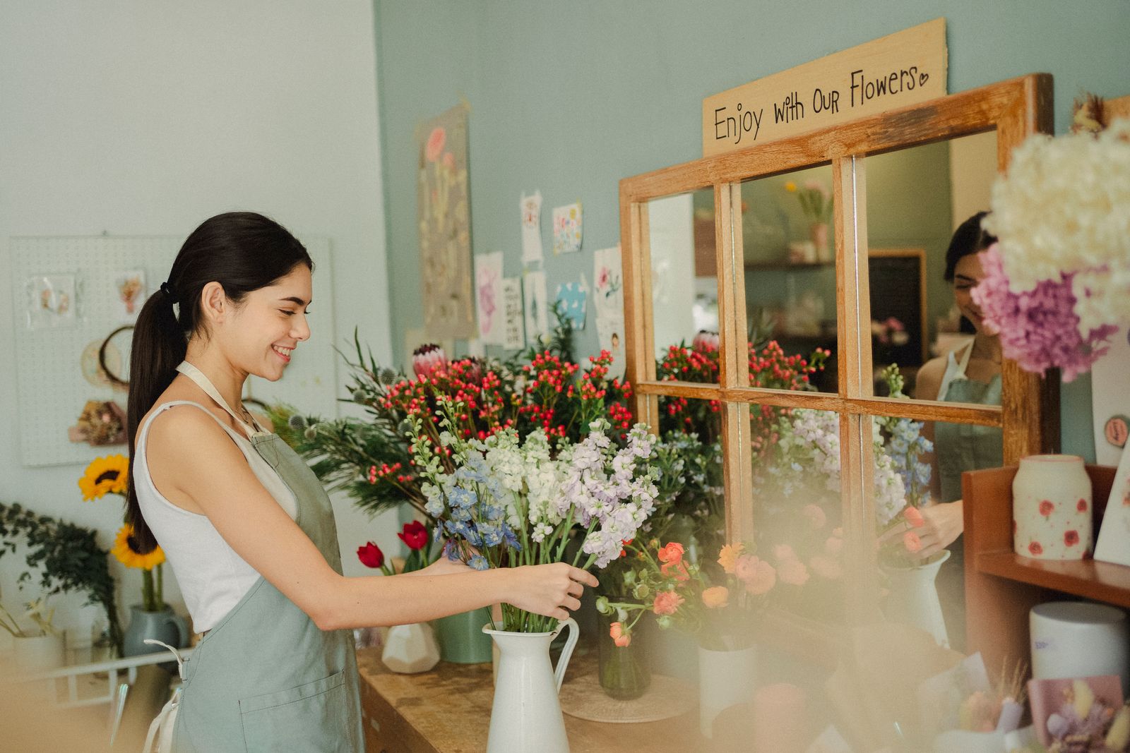 Smiling shop owner working happily in her flower shop