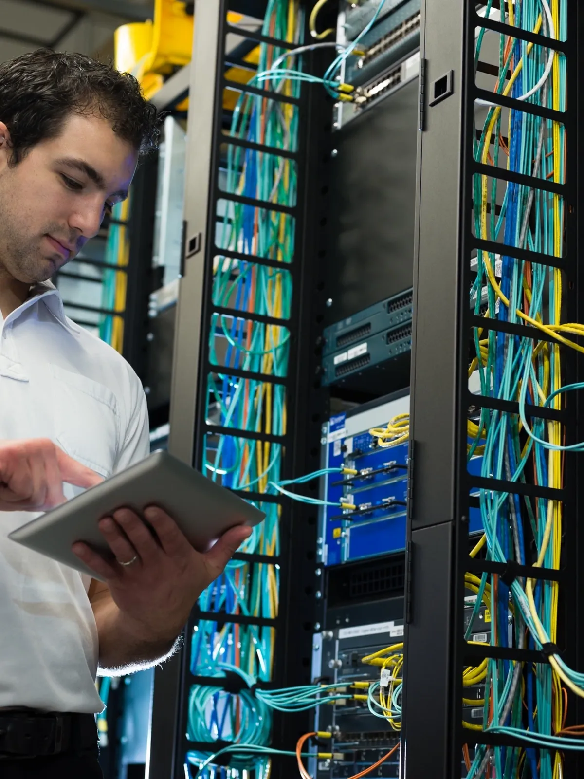 Technician viewing tablet in server room
