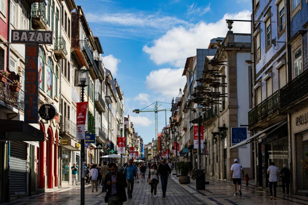 Busy pedestrian street lined with shops and historic buildings in Porto.