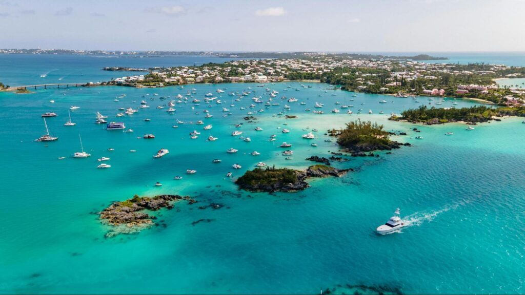 Aerial view of a turquoise bay filled with boats and yachts.