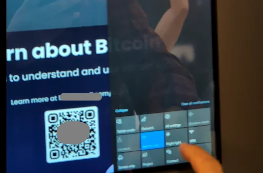 Person interacting with a secure mobile app interface displaying Bitcoin information and QR code