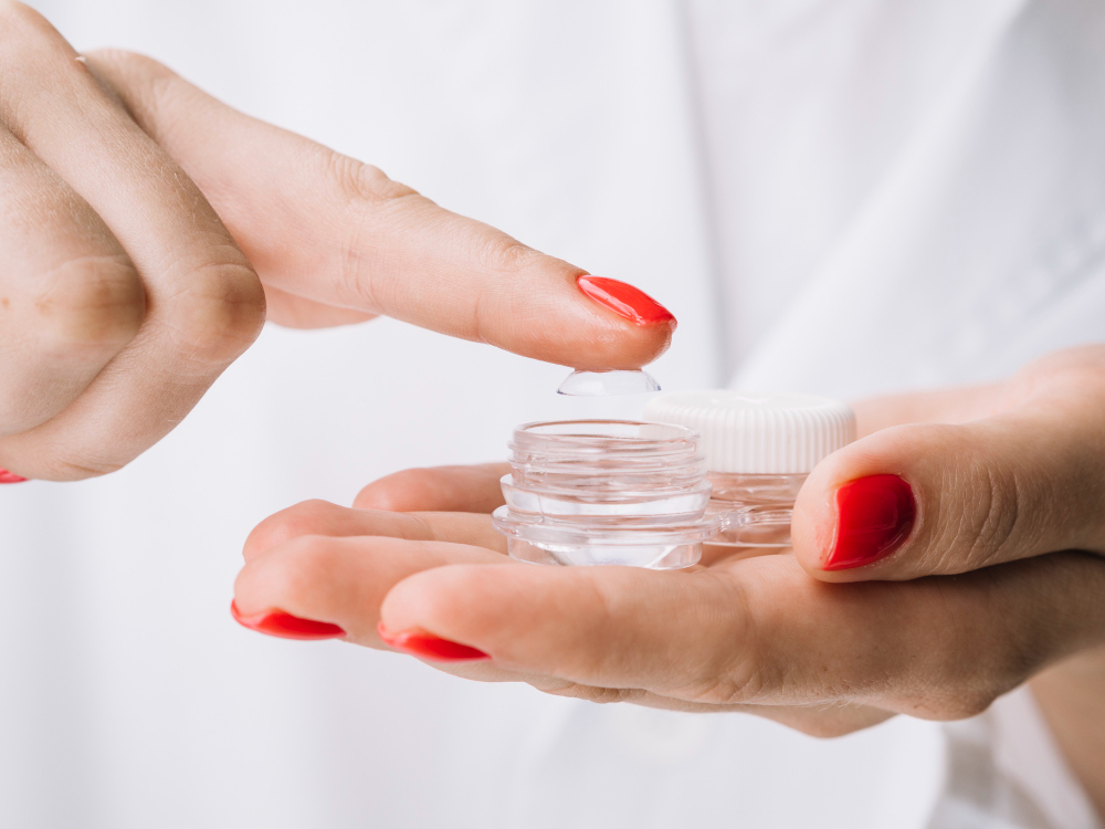 A woman holding contact lenses 
