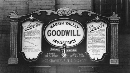 Historical black and white sign for Wabash Valley Goodwill Industries displaying their motto and principles.