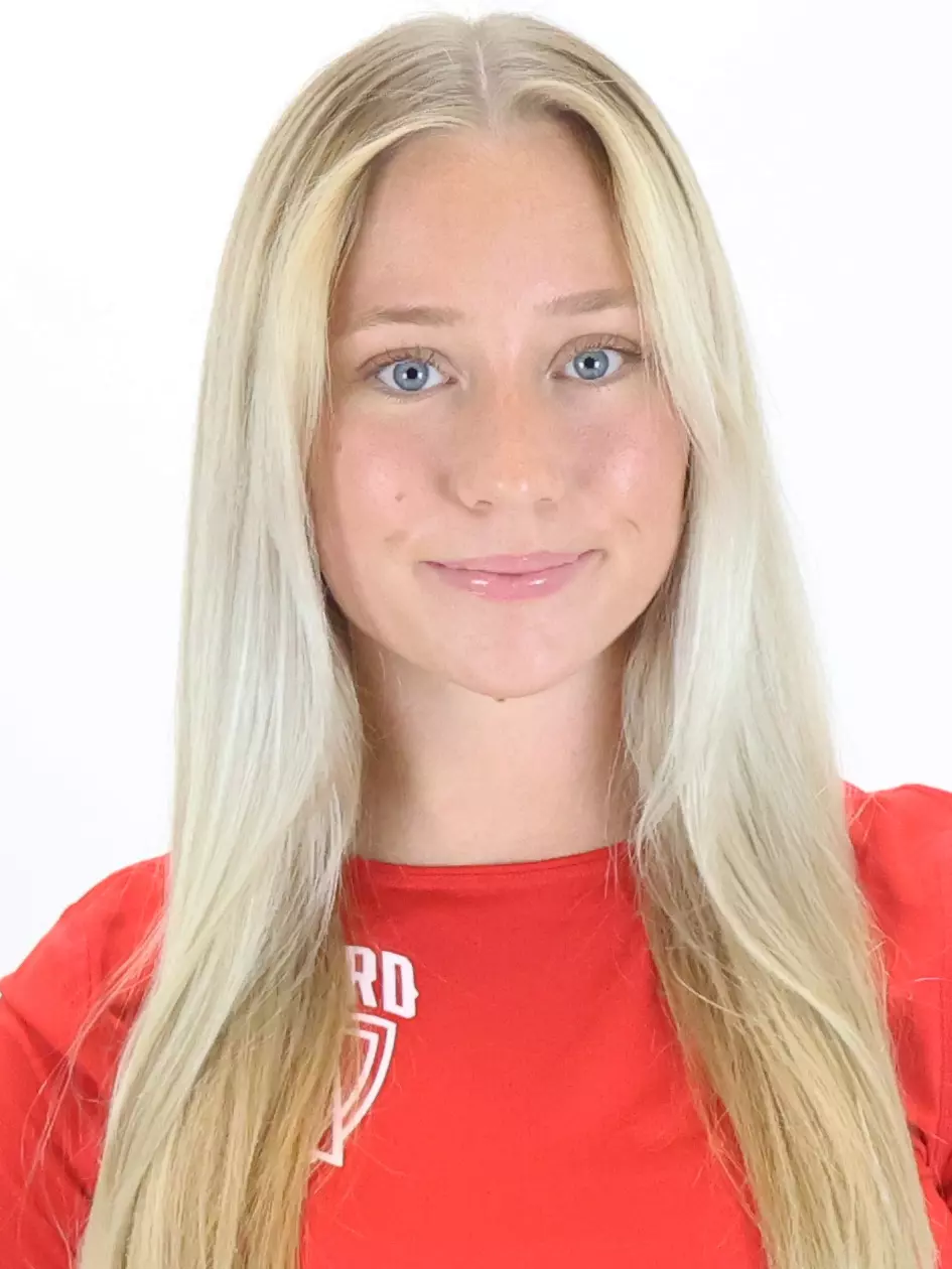 A headshot picture of a female student in a red shirt and blonde hair.