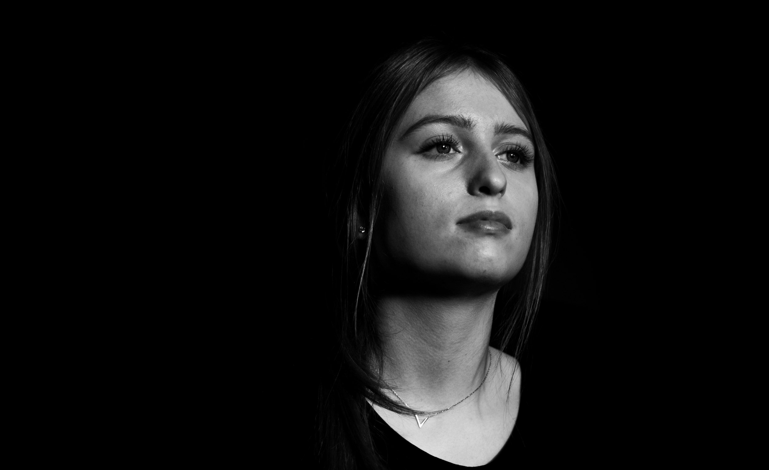 Zwart-wit portret van een jonge vrouw met halflang haar, kijkend naar rechts met een neutrale uitdrukking.