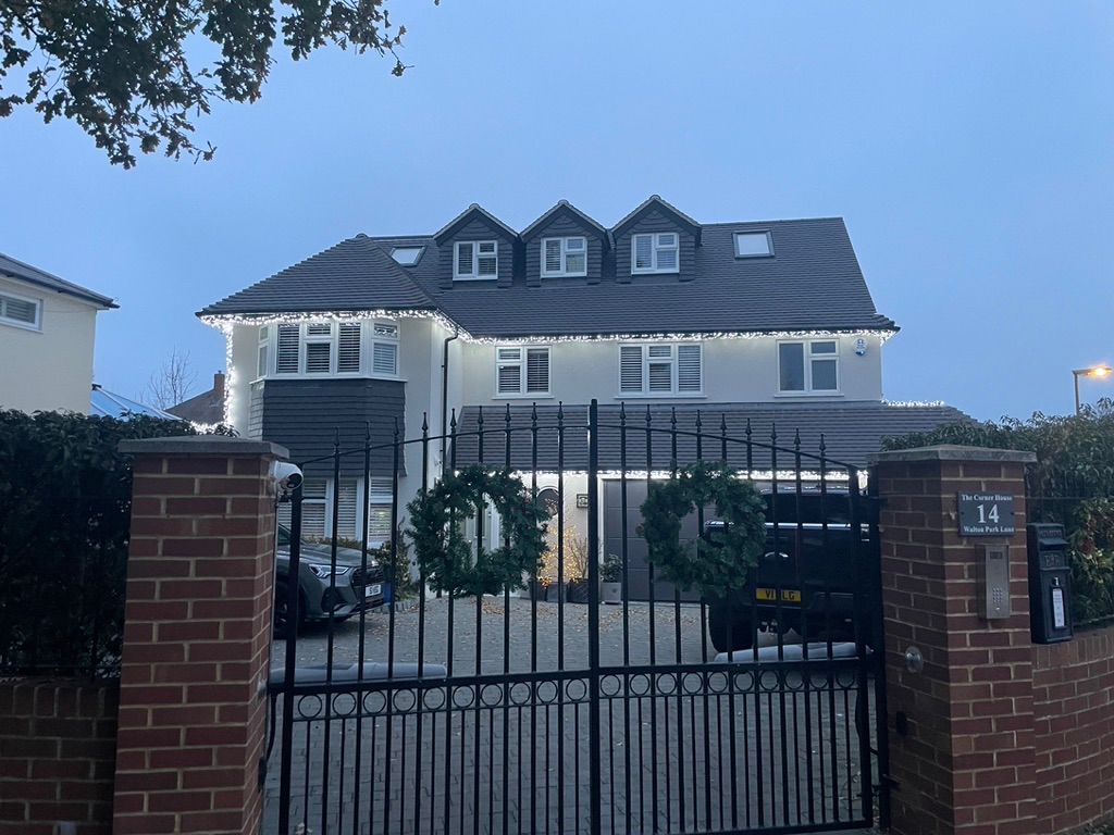 Renovated home with loft extension featuring grey roof, dormer window, and modern exterior finish