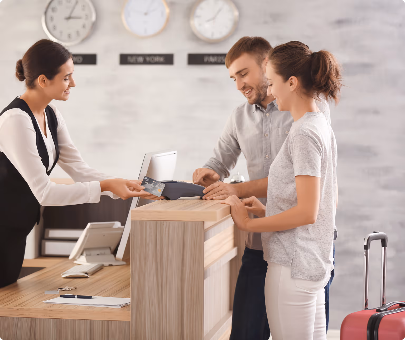 À l'accueil d'un hôtel, les clients sont satisfaits de leur séjour grâce à une gestion des performances optimisée via les outils de l'hôtel