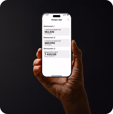 Main tenant un smartphone affichant un écran d'application avec les totaux de ventes en temps réel pour trois restaurants.